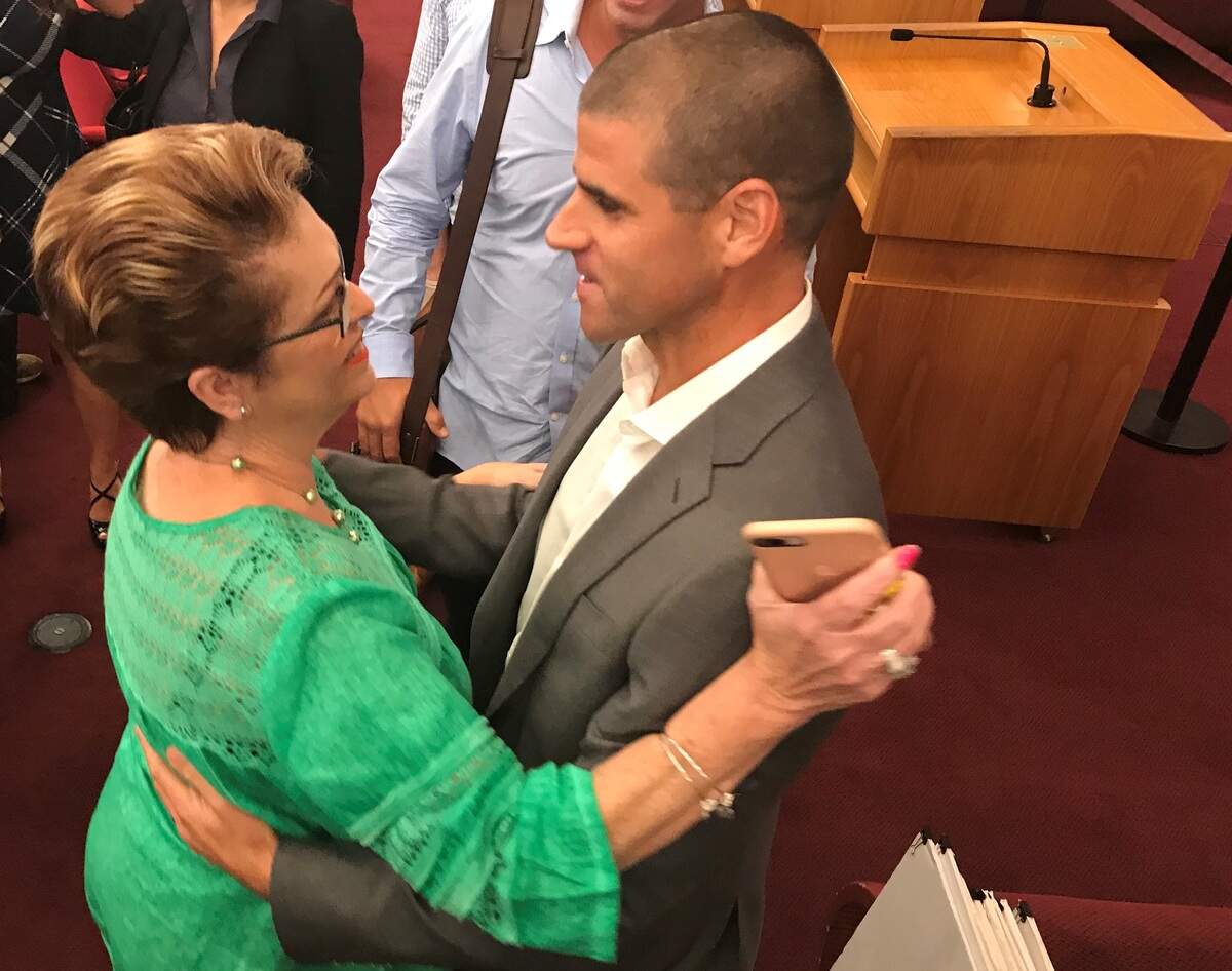 Miami-Dade Commissioner Rebeca Sosa hugs Frankie Ruiz, a leading Miami runner and coach, after a commission vote to spend $25 million buying a five-mile abandoned railway in 2018. Miami-Dade plans to convert the land to the Ludlam Trail park, a hiking and biking trail.